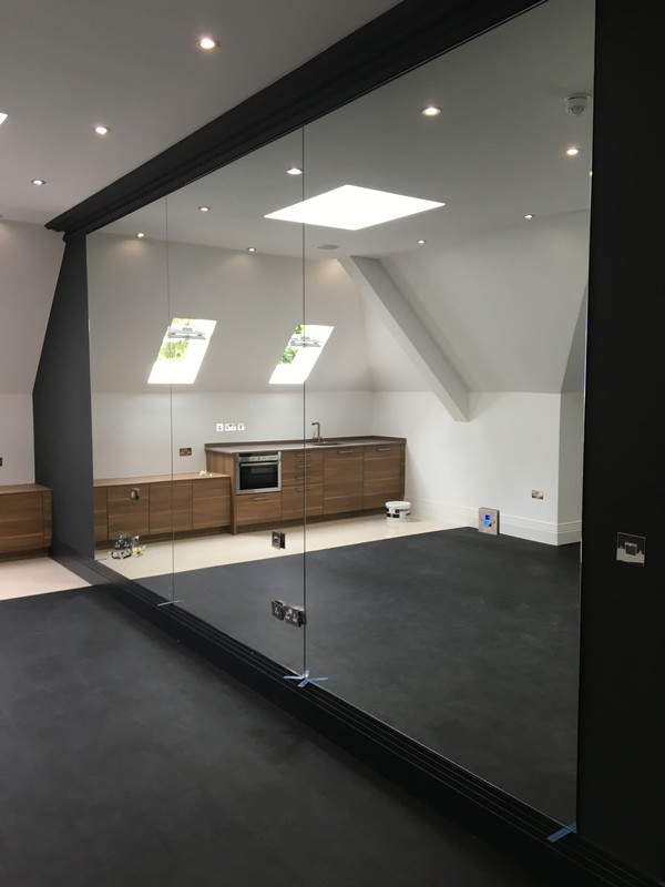 Frameless glass partition in loft conversion by Bushey glaziers