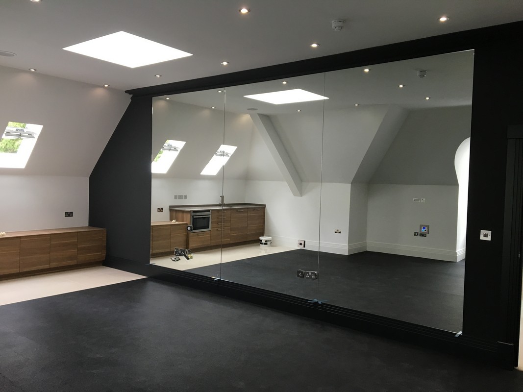 Frameless glass wall dividing loft conversion in Bushey